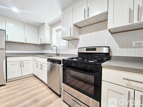 A modern kitchen with a stainless steel oven and white cabinets.