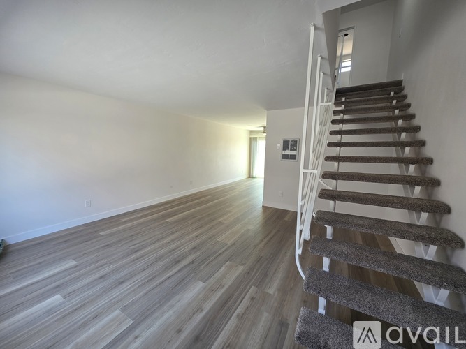 A carpeted room with a doorway leading to another room.