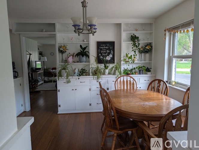 A dining room with a wooden table surrounded by chairs.