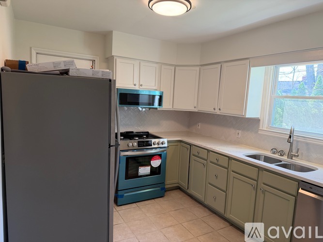 A kitchen with a refrigerator, oven, and cabinets.