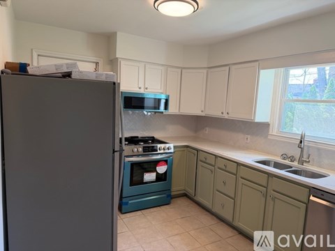 A kitchen with a refrigerator, oven, and cabinets.