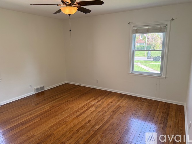 A room with wooden flooring and a ceiling fan.