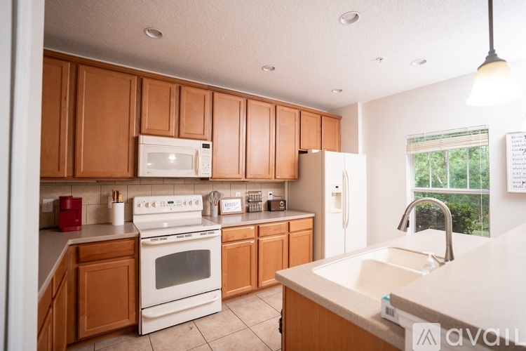 A kitchen with wooden cabinets and white appliances.