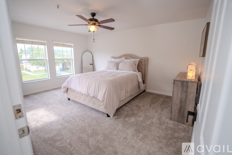 A bedroom with a large bed and a ceiling fan.