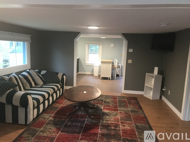 A living room with a striped couch and a round table.