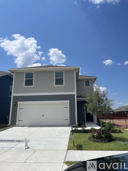 A house with a garage and a driveway in front.