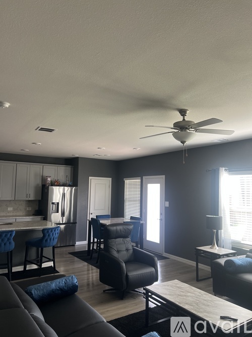 A modern living room with a grey sofa and a ceiling fan.