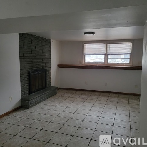 A living room with a fireplace and a window.