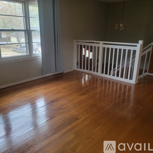 A room with wooden floors and a white railing.