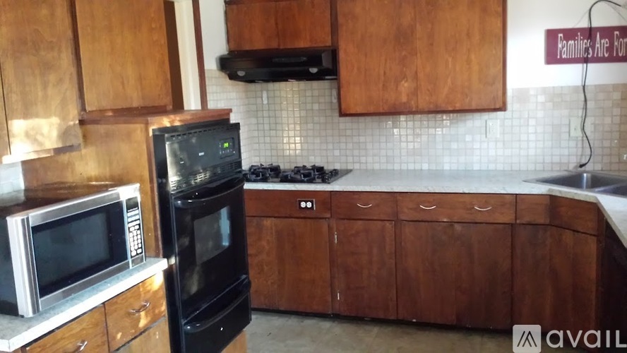 A kitchen with wooden cabinets and a black oven.