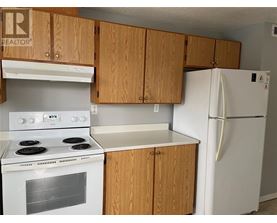 A kitchen with a white stove and refrigerator.