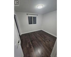 A room with a window and wooden flooring.