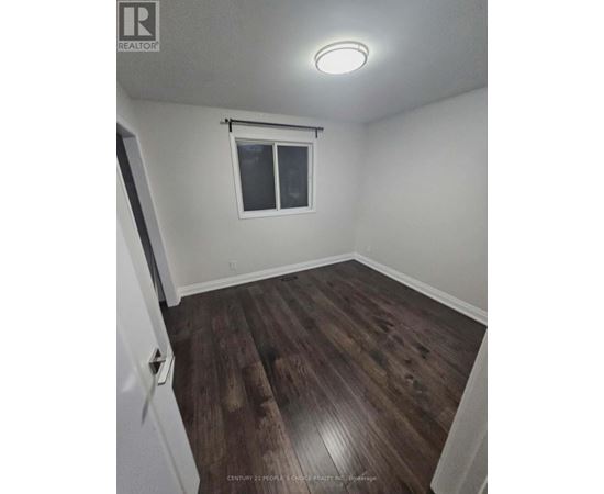 A room with a window and wooden flooring.