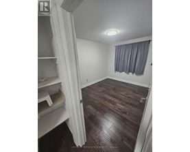 A room with wooden floors and a window with curtains.