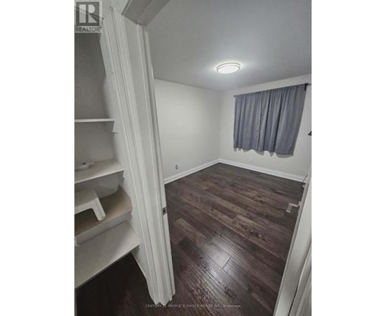 A room with wooden floors and a window with curtains.