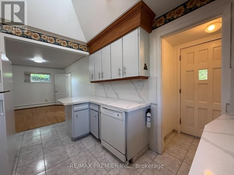 A kitchen with white cabinets and a wooden counter top.