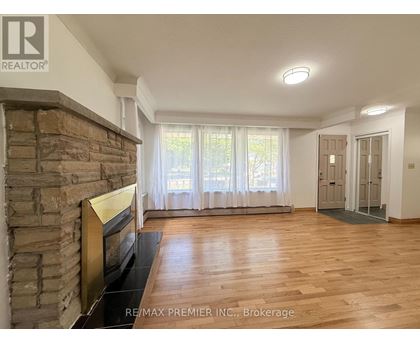 A living room with a stone fireplace and hardwood floors.