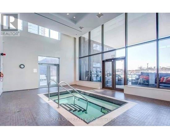 A large, empty room with a glass wall and a pool table.