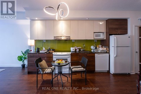 A modern kitchen with a dining table set for two.