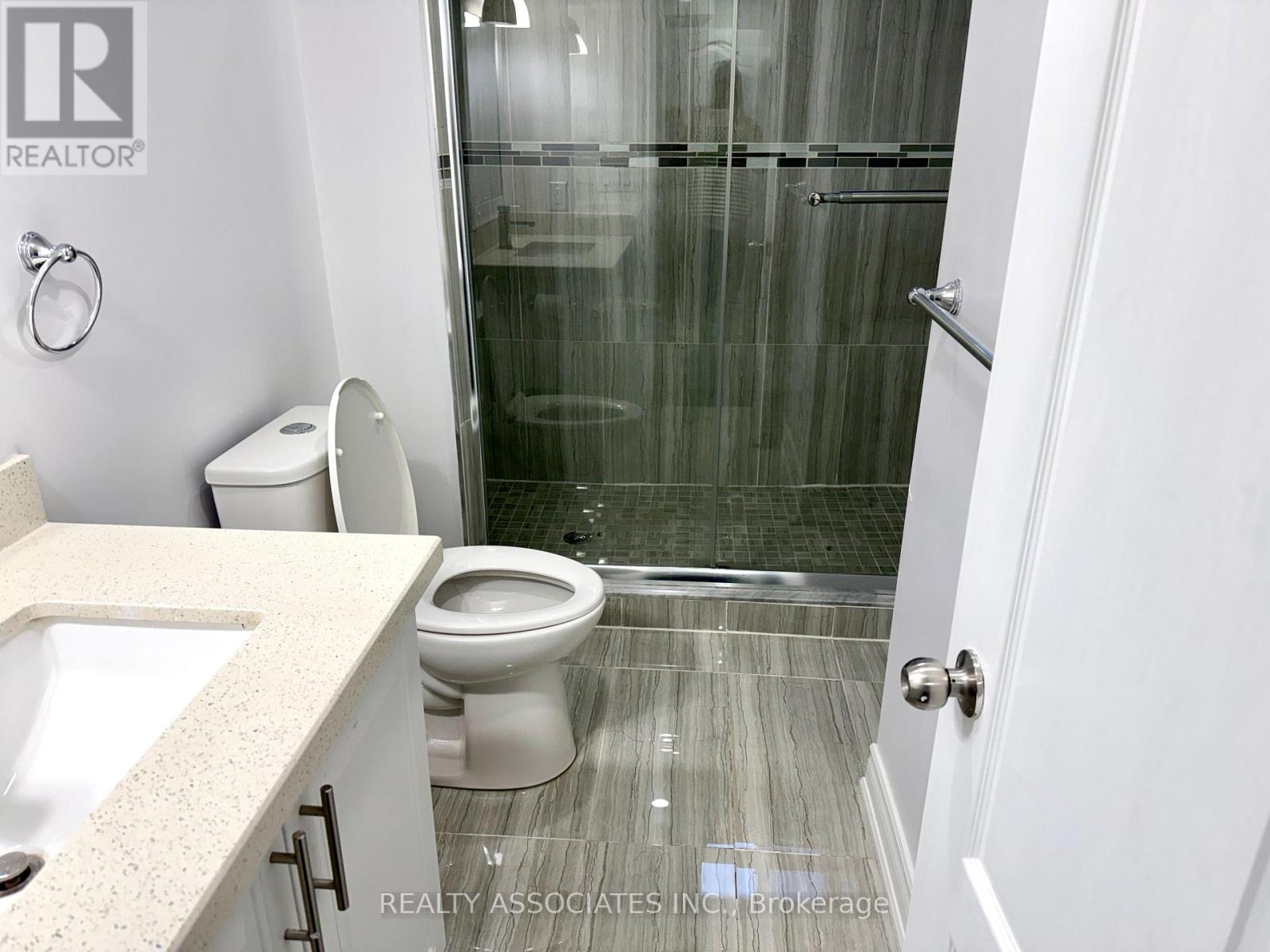 A bathroom with a toilet, sink, and shower.