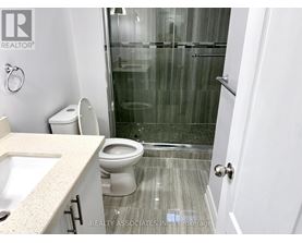 A bathroom with a toilet, sink, and shower.