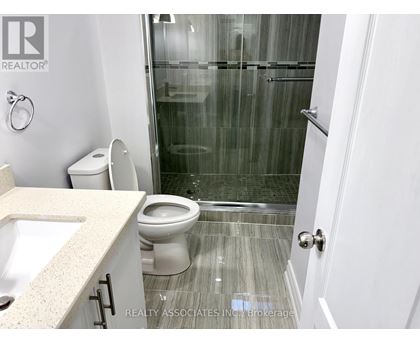 A bathroom with a toilet, sink, and shower.