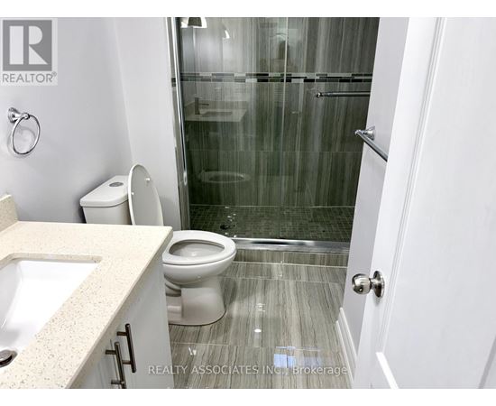 A bathroom with a toilet, sink, and shower.