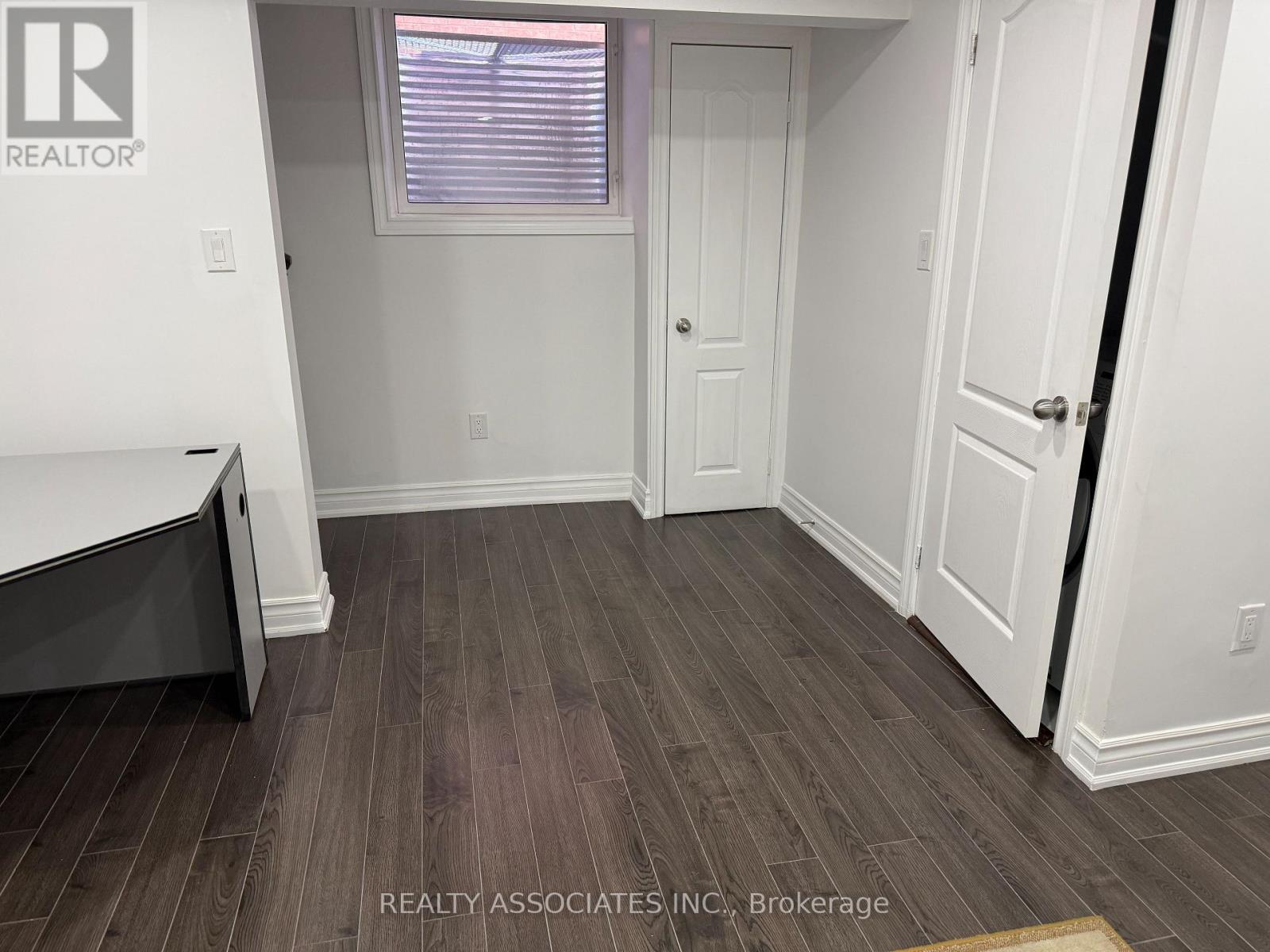 A room with a wooden floor and white walls.
