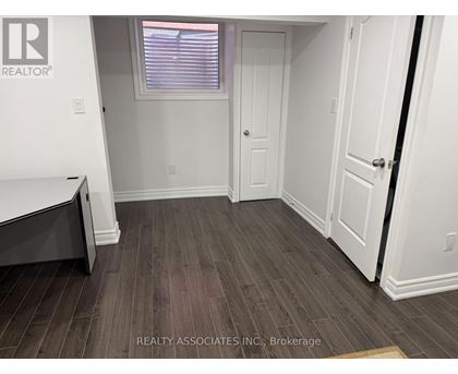 A room with a wooden floor and white walls.