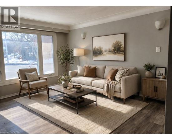 A living room with a couch, chair, and a painting on the wall.