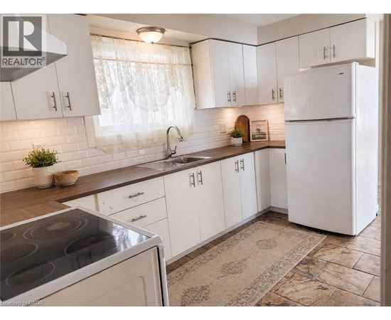 A kitchen with white cabinets and a tiled backsplash.