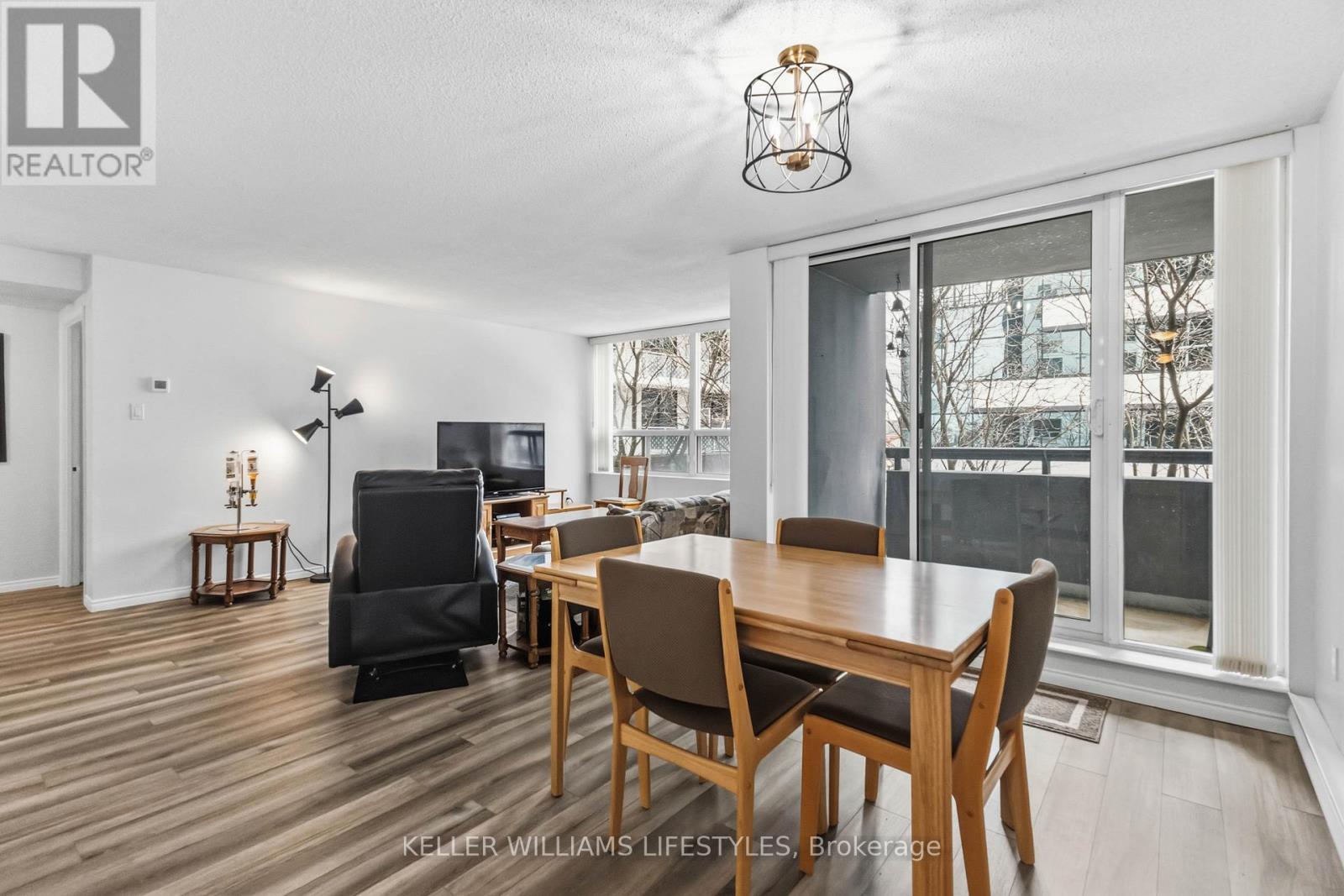 A well-lit dining room with a wooden table and chairs.