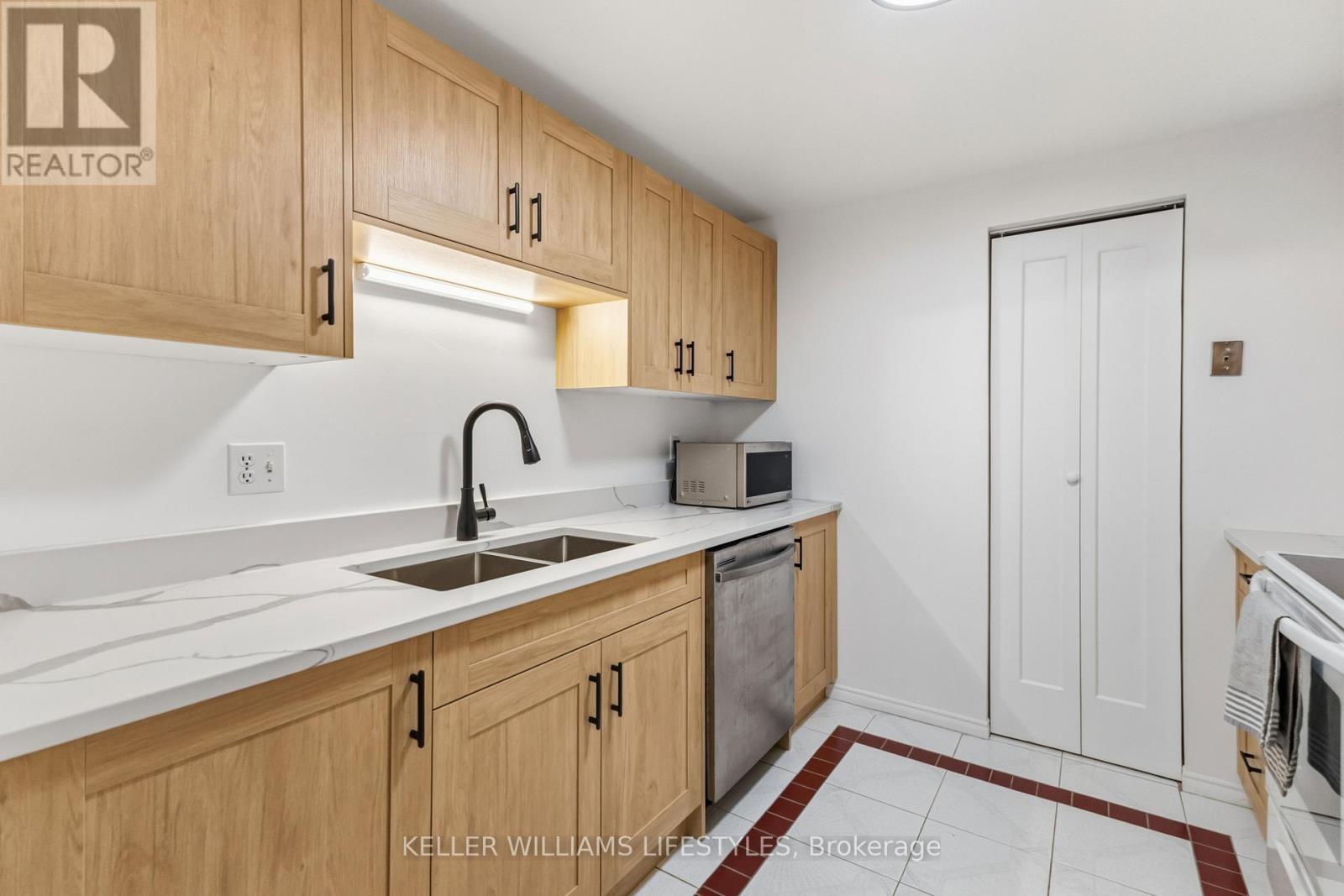 A kitchen with wooden cabinets and a white counter top.