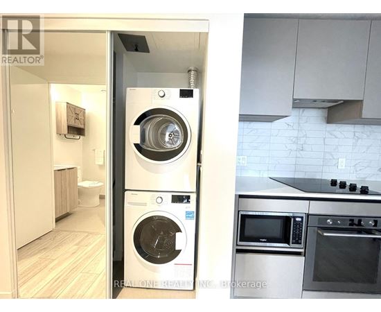 A modern kitchen with a washer and dryer built into the cabinetry.