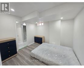 A bedroom with a bed, dresser, and mirror.