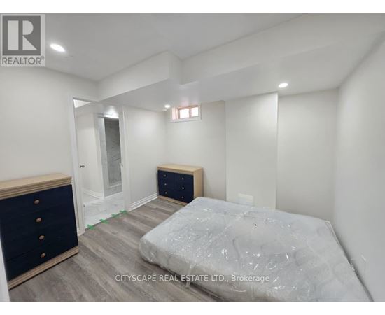 A bedroom with a bed, dresser, and mirror.