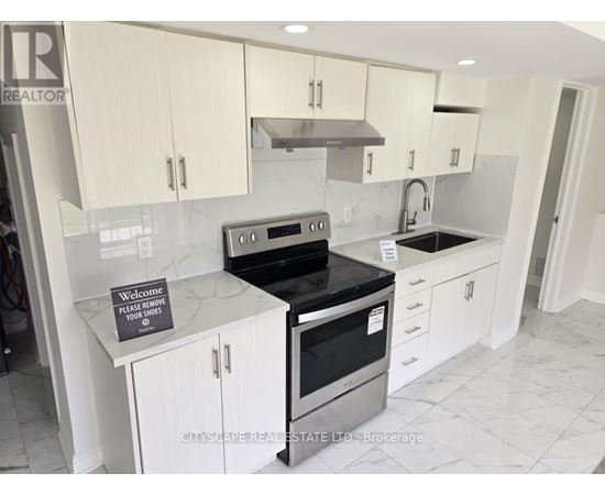 A kitchen with a sign on the counter that says "Please remove your shoes".