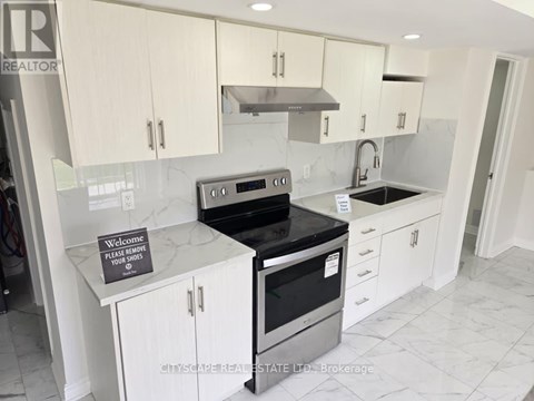 A kitchen with a sign on the counter that says "Please remove your shoes".