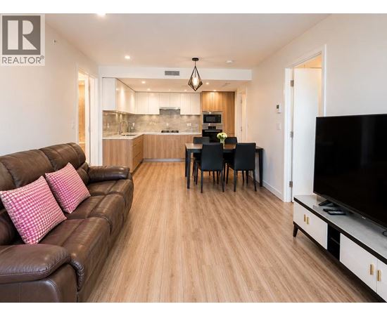 A living room with a brown leather couch and a wooden floor.