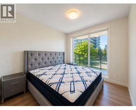 A bedroom with a large bed and a window overlooking a balcony.