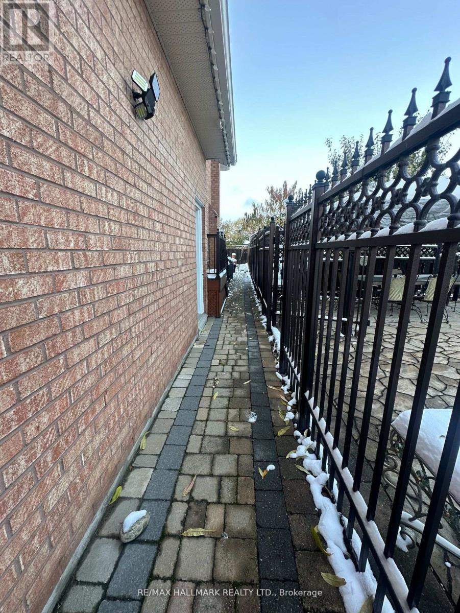 A brick wall with a black iron fence in front of it.