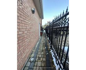 A brick wall with a black iron fence in front of it.