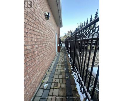 A brick wall with a black iron fence in front of it.