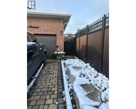 A black truck is parked in front of a house with a sign that says "RE/MAX Hallmark Realty, Brockton.".