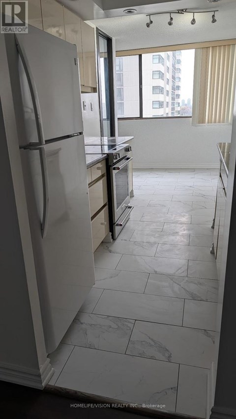 A kitchen with a refrigerator and a counter top.