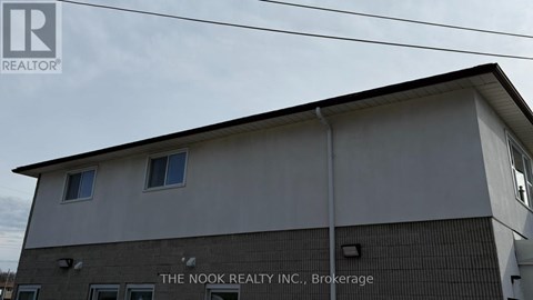 The Nook Realty Inc. Brokerage sign is on the side of a building.