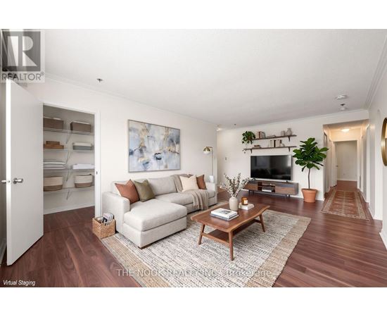 A living room with a white couch, a coffee table, and a painting on the wall.