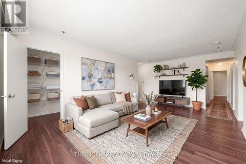 A living room with a white couch, a coffee table, and a painting on the wall.