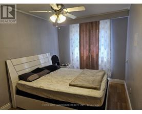 A bedroom with a bed, pillows, and a ceiling fan.