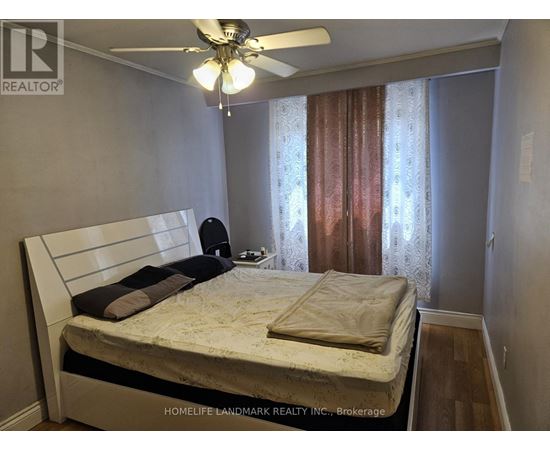 A bedroom with a bed, pillows, and a ceiling fan.
